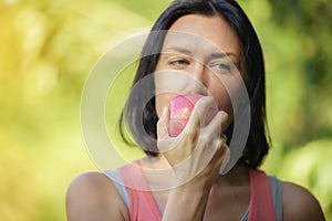 Older woman is eating apple after exercising to take care of the