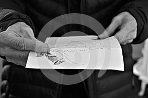 Older woman holds handwritten letter with bird motif