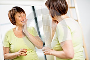 Older woman looking into the mirror