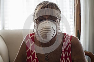 Older woman in quarantine with chinstrap at home due to coronavirus