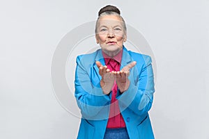 Older woman sending air kiss at camera