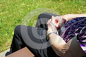 Older woman sits on bench with portable oxygen tube