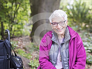 Older Woman Sitting in Park Beside her Wheelchair