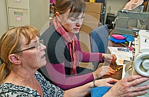 Older Woman Teaching Younger Woman to Sew