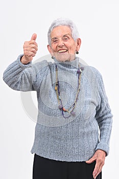 Older woman with thumbs up and smile on white background photo