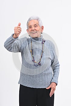 Older woman with thumbs up and smile on white background photo