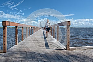 Older woman walking on dock, Stuart, FL