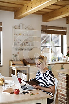 Older woman working from homeoffice. The retiree earning extra money during retirement. Woman paying bills online.