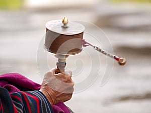 An older women spinning her prayer wheel