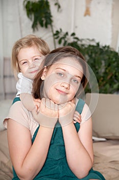 Older and younger sisters hugging in   home interior