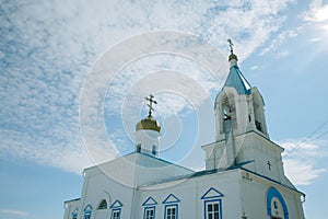 The oldest Church is blue and white with a Golden dome and cross. Above the Church is a blue sky