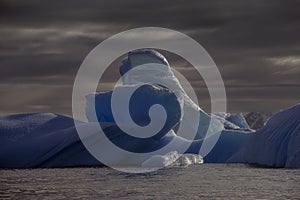 Deep blue ancient glacial iceberg,  Antarctica photo