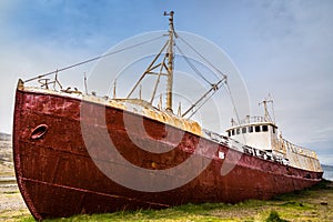 Oldest steel ship in Iceland abandoned rusty ashore in the grass