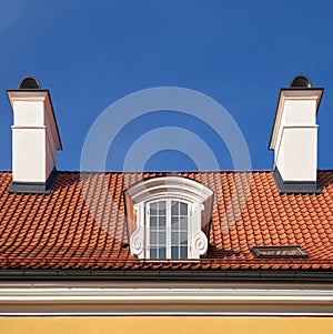 Oldgarret roof with window and chimneys. Retro attic window and fireplace chimneys,