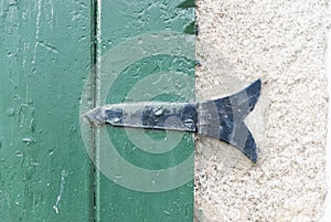 Oldie hinge in green wooden windows textured wall