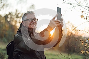 Oldman doing selfie in sunset