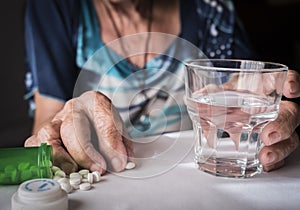 Oldster taking daily medication dose at home