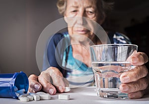 Oldster taking daily medication dose at home