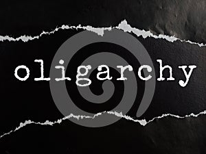 Oligarchy text title on black torn paper background