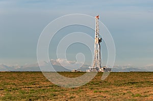 Olil rig in the morning with mountains in the background
