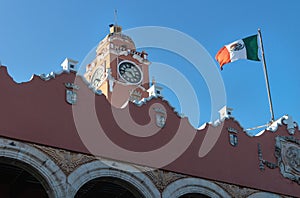 Olimpo Cultural Center with tower and blown flag on cloudless blue sky, Merida, Yucatan, Mexico photo