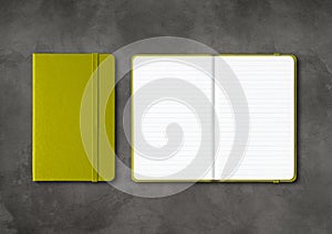 Olive green closed and open lined notebooks on dark concrete background