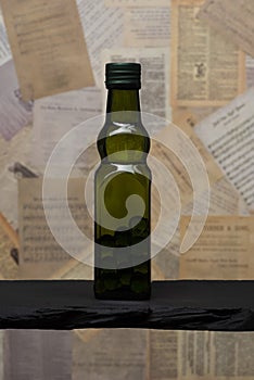 Olive green glass bottle filled glass marble Spheres on antique paper background