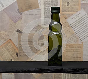 Olive green glass bottle filled glass marble Spheres on antique paper background