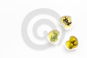 Olive oil as famous product of mediterranean cuisine. Heart shaped bowls with olive oil with green olives, rosemary and