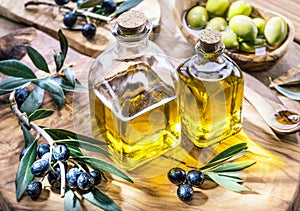 Olive oil and berries are on the olive wooden tray.