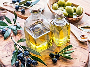 Olive oil and berries are on the olive wooden tray.