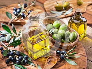 Olive oil and berries are on the olive wooden tray.