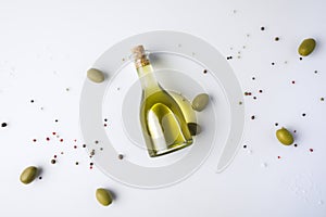 Olive oil bottle with cork and olives