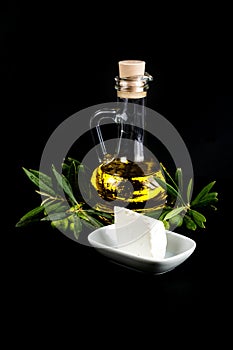 Olive oil bottle, olive branch, and white cheese