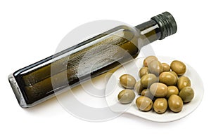 Olive oil bottle and olives fruits at plate isolated