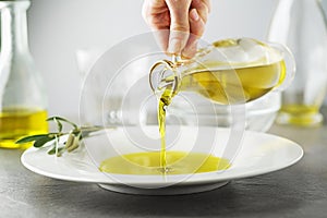 Olive oil bottle pouring close up