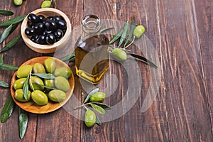 An olive oil in the bottle and some olives and branches