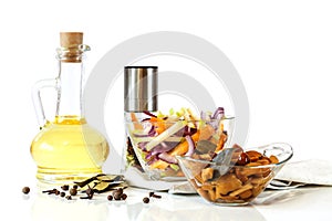 Olive oil and delicious marinated mushrooms and salad in glass bowls