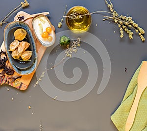 Olive oil, dried herbs, Physalis on table