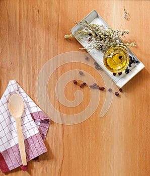 Olive oil with dried herbs on wooden background