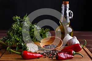 Olive oil, garlic, herbs and spices on wooden table. Kitchen bac