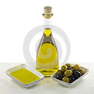 Olive oil in glass bottle and dish, and olives snack