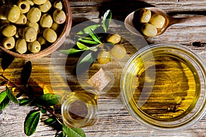 Olive oil in a glass bowl. olives in a wooden cup