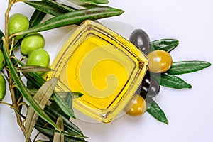 Olive oil. Greek olive oil in square glass transparent bowl with fresh and marinated olives and leaves. Close-up, Isolated on