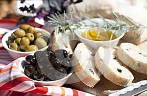 Olive oil, green and black olives on the table