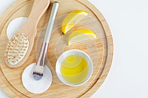 Olive oil, lemon slices, cotton pad, cosmetic brush and wooden hairbrush. Ingredients for preparing homemade mask.