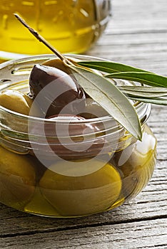 Olive oil with olives and branch