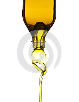 Olive oil pouring from glass bottle