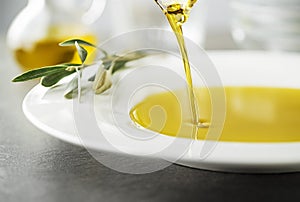 Olive oil pouring on olive background