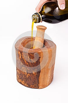 Olive oil pouring Into olive wood mortal and pestle